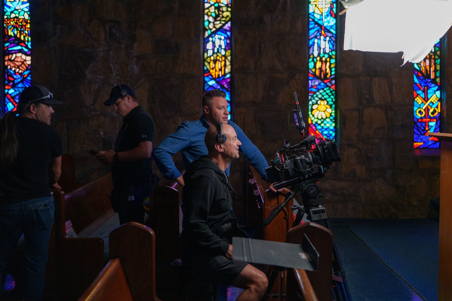 The camera team working inside a stained-glass church set.