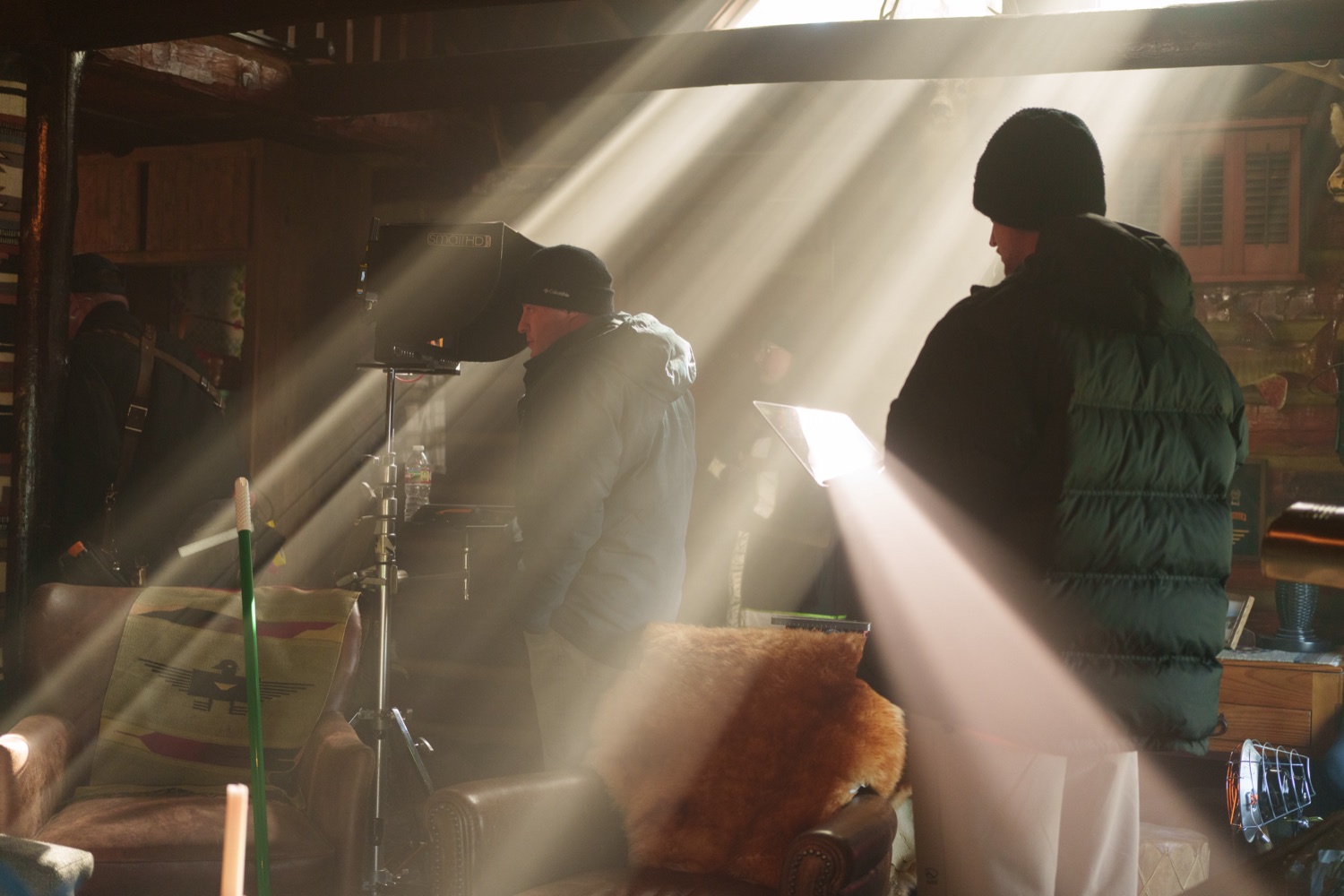Crew silhouetted in shafts of light on a period interior set.
